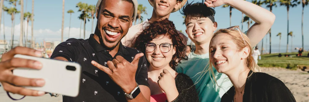 Friends taking a group selfie at the beach