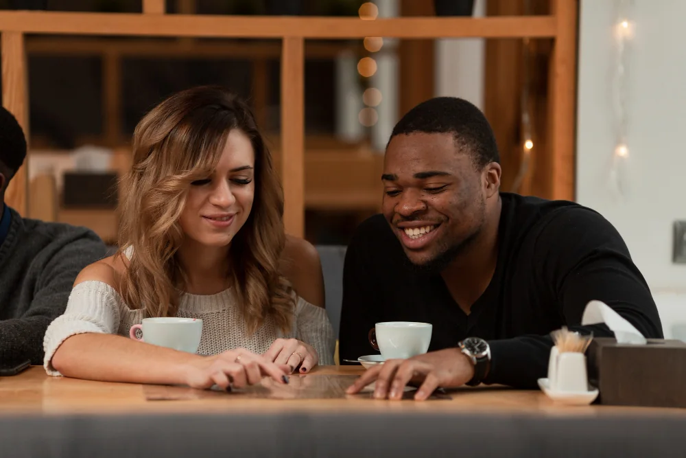 Two people talking over coffee at a café